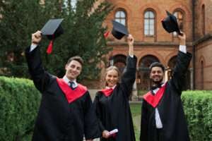 Students celebrating their graduation with smiling faces throwing hats in the air
